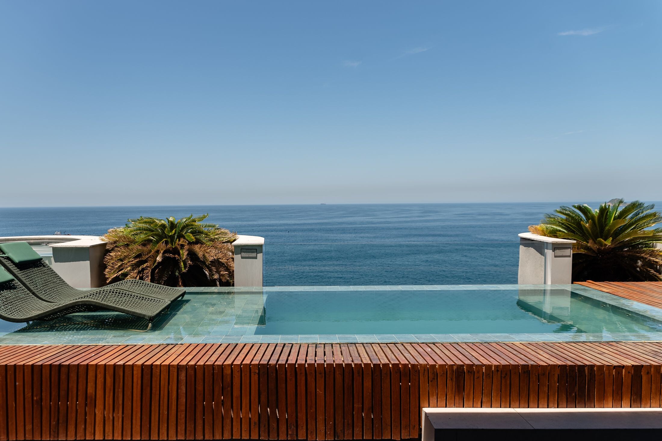 Oceanfront retreat setting with an infinity pool and tropical landscape